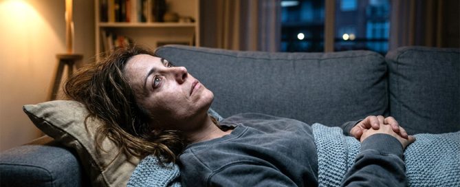 Mujer con expresión de agotamiento emocional y pensamiento rumiativo mirando al techo, representando el enganche emocional y la dificultad para dejar de pensar en alguien.