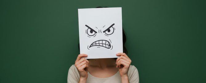 Persona con expresión tensa y agotada que se enfada con facilidad, representando la irritabilidad como síntoma de sobrecarga emocional.